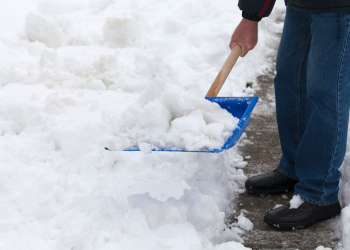 A person shoveling snow on a sidewalk