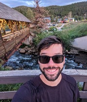 Austin Everett stands on a bridge over a river.