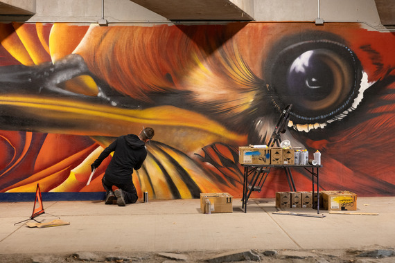 Artist AJ Davis works on the mural in the McCaslin Boulevard underpass