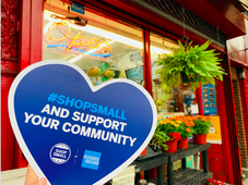 Heart reading "shop small and support your community" in front of a local business