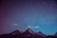 Stars in the night sky with a mountain backdrop