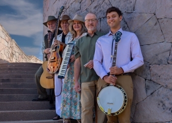 Micrograss Band members standing on a staircase with their instruments.