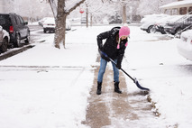 Person shovels snow from the sidewalk
