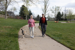 Two people walking on a path in Superior with dog on a leash.