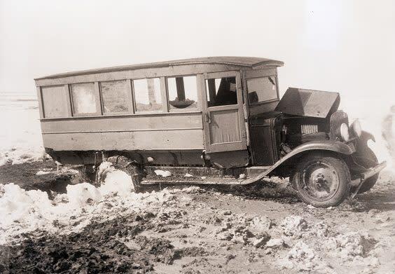 Black and white photo of old broken-down bus.
