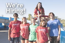 Pool lifeguards pose by lifeguard stand