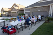 Group of neighbors sitting at tables for a block party.