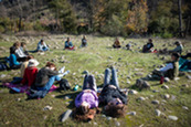 People relax in the grass during a nature and forest therapy event