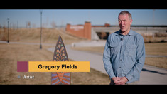 Greagory standing next to the Seeker and Field statue.