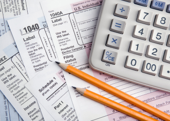 Tax forms with pencils and a calculator