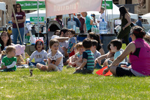 A group of kids laughing in the grass during the 2023 Arbor Day event
