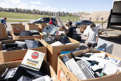 Full bins of collected recyclables sitting in a parking lot during the hard to recycle event.
