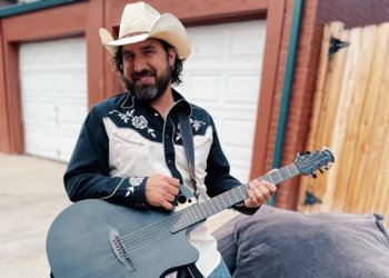 Musician Aaron Rose poses with a guitar