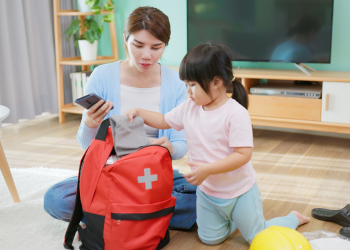 A woman and a child look into an emergency go bag
