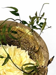 Blurry photo of leaves on a rock that's bending around flowers.