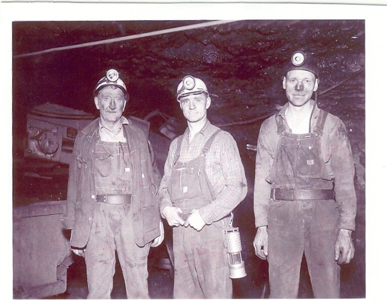 Black and white photo of miners posing deep in the Superior mines.
