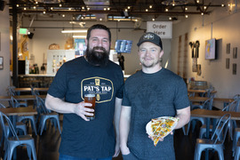 Pat's Tap, owners smiling & holding beer & pizza