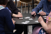 up close shot of 4 seniors sitting around a table playing euchre