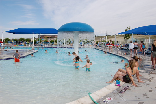 Swimmers play around the mushroom fountain at the South Pool in Superior