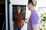 Commission Chair Larry Dorrsey greeting someone with a handshake as the visit the Historical Musem.