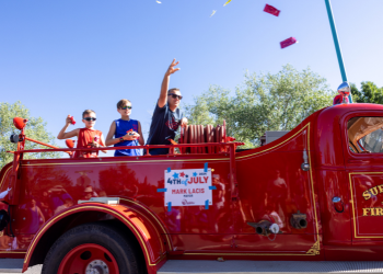 Mayor Mark Lacis tosses items off Superior's historic fire truck 4th of July