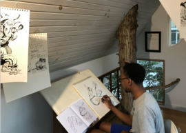A person drawing in a treehouse studio