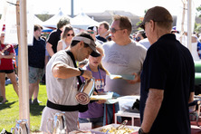 People in a line grabbing pancakes during the festival.