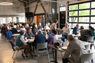 A crowd of people sits at tables during the Senior Welcome Breakfast 