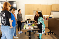 Participants watch as Chef Akila makes a meal in an Indian Cooking Class