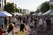 A crowd walks down Superior's Main Street as it's lined with vendors during the Summer Market