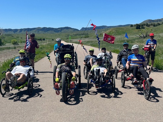 A group of people riding bikes on a trail, many are using recumbent-style bicycles