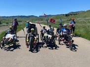 A group of people riding bikes on a trail, many are using recumbent-style bicycles