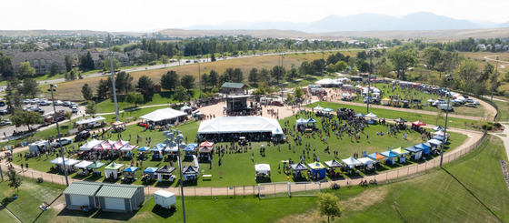 Drone shot of the festival with people and tents scattered everywhere.