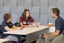 3 people sitting at a table having a conversation at the downtown superior civic space