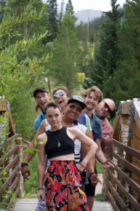 Six members of los cheesies band pose on a bridge.
