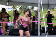 A woman in a pink shirt and black shorts dances at the Summer Concert Series