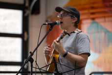 person singing and playing the ukulele at open mic night