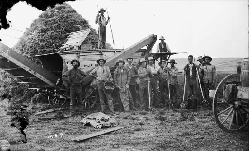 Threshers take a rest in front of their machine.