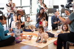toddlers and parents holding their thumbs up during an interactive family story time