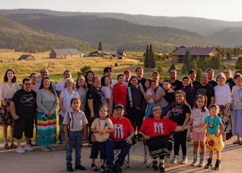 A group of people from Right Relations smile for a photo with a mountain backdrop