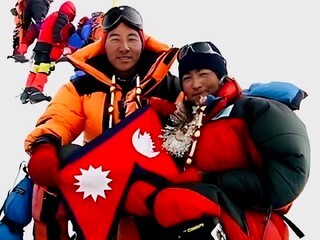 Pem Dorjee and Moni Mulepati with a Nepalese flag on the summit of Mount Everest