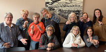 group photo of superior seniors proudly holding up their creations during senior crafting club