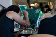 A woman paints on a canvas
