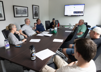 Eight members of the Superior Veterans Group sit around a conference table during a monthly meetup