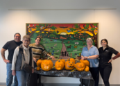 Five people pose with carved pumpkins at the Superior Community Center