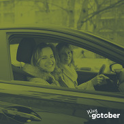 Two people in a car with green color overlay and text "Way to Go-Tober"