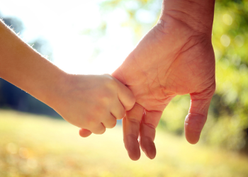 An adult and a child holding hands