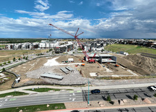 Crane working on the start of a large building with a rainbow behind it.
