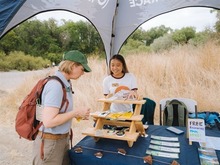 People visiting outside at a Leave no Trace Tent.