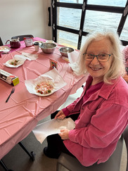 A Superior Senior smiles with a snack during a meetup at the community center